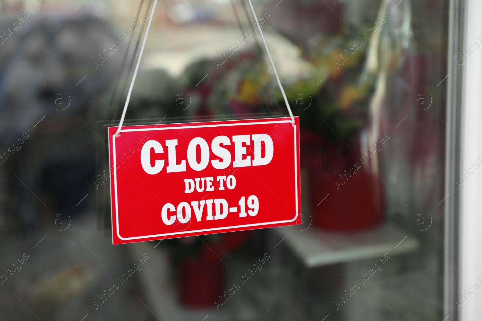 Photo of Red sign with text Closed Due To Covid-19 hanging on glass door. Coronavirus quarantine