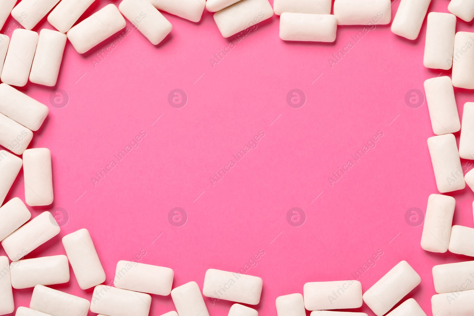 Photo of Frame of chewing gum pieces on pink background, flat lay. Space for text