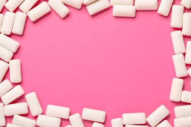 Photo of Frame of chewing gum pieces on pink background, flat lay. Space for text