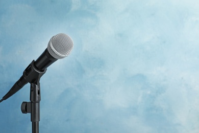 Modern microphone on color background. Space for text