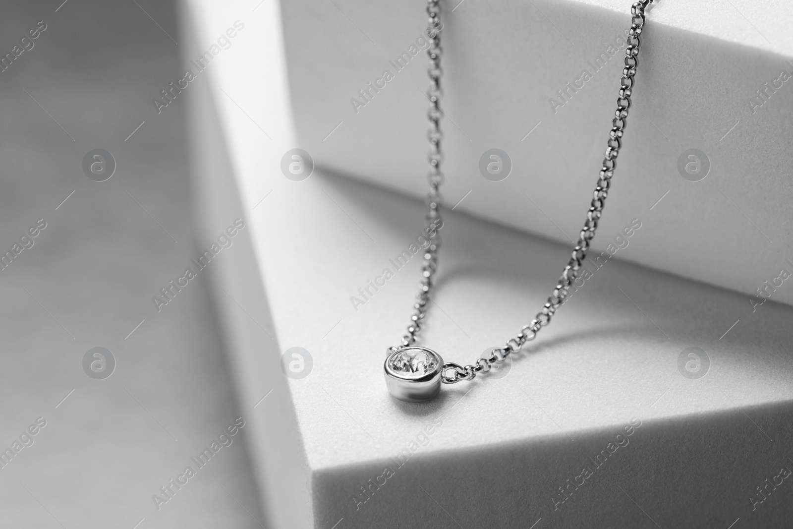 Photo of Beautiful necklace with gemstone on white podiums. Luxury jewelry
