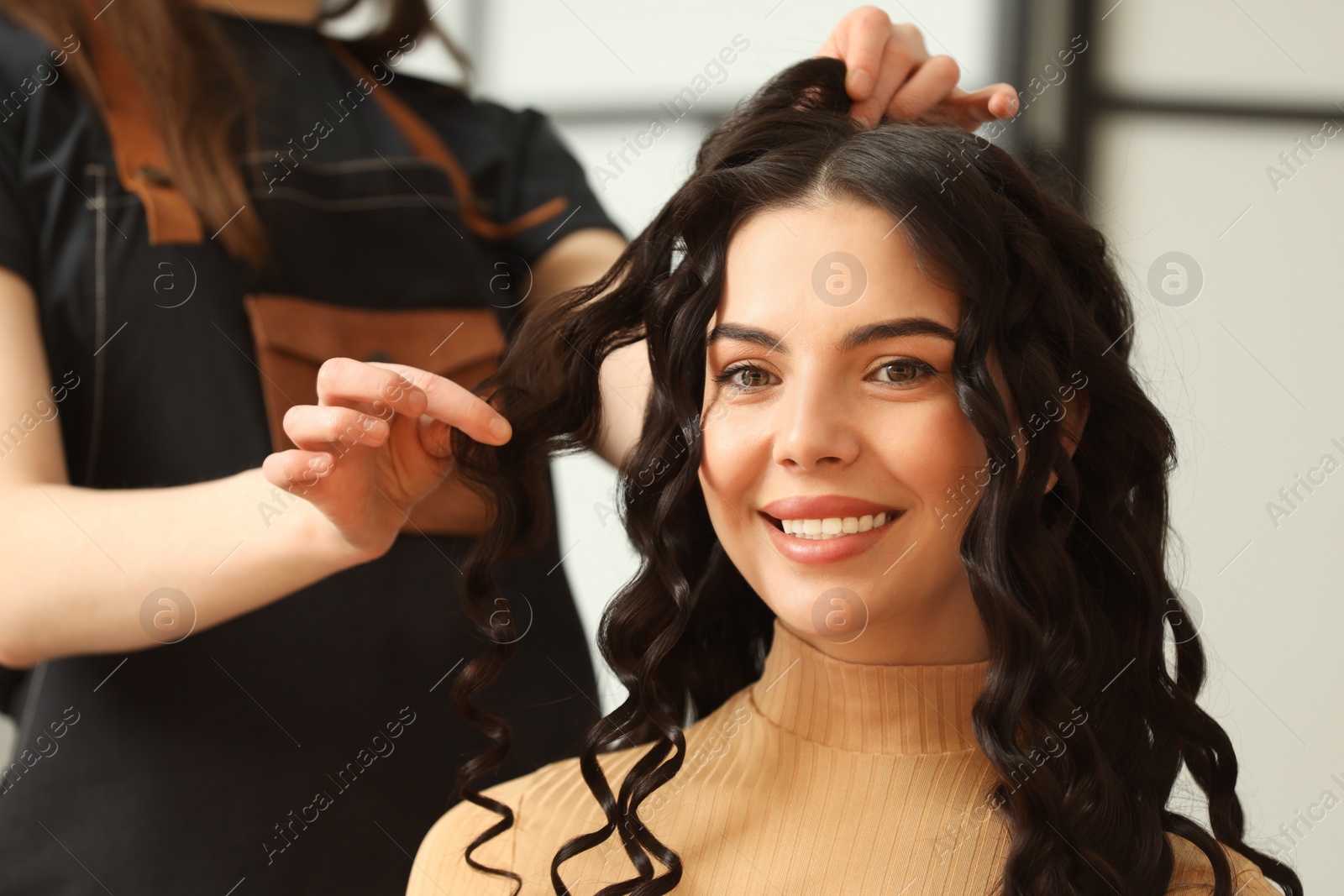 Photo of Hair styling. Professional hairdresser working with smiling client indoors, closeup