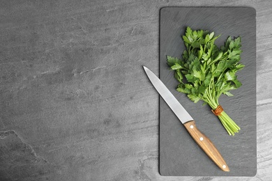 Photo of Flat lay composition with fresh green parsley and knife on grey background. Space for text