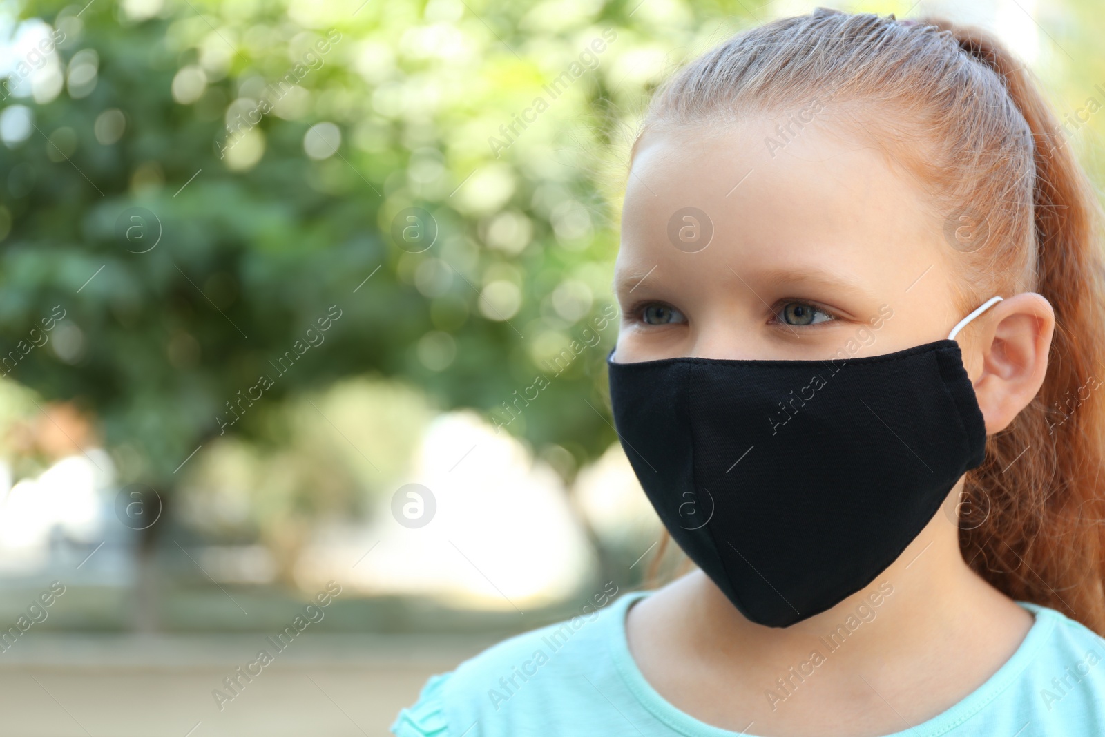 Photo of Preteen girl in protective face mask outdoors