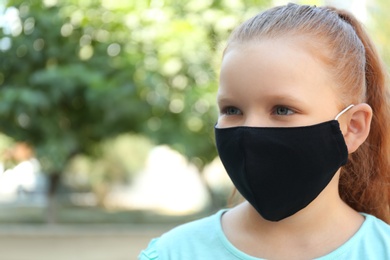 Photo of Preteen girl in protective face mask outdoors