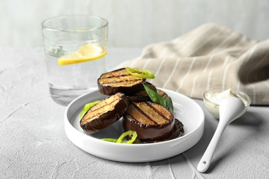 Plate with fried eggplant slices on table