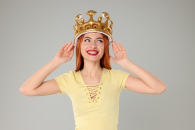 Photo of Beautiful young woman with inflatable crown on light grey background