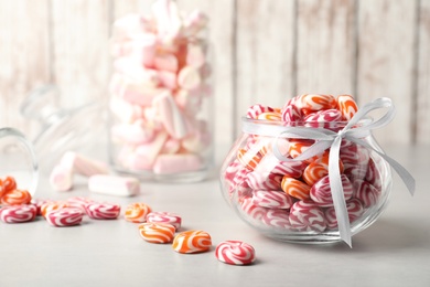 Photo of Delicious sweet candies on light grey table