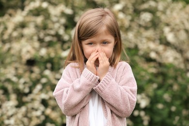Little girl suffering from seasonal pollen allergy on spring day