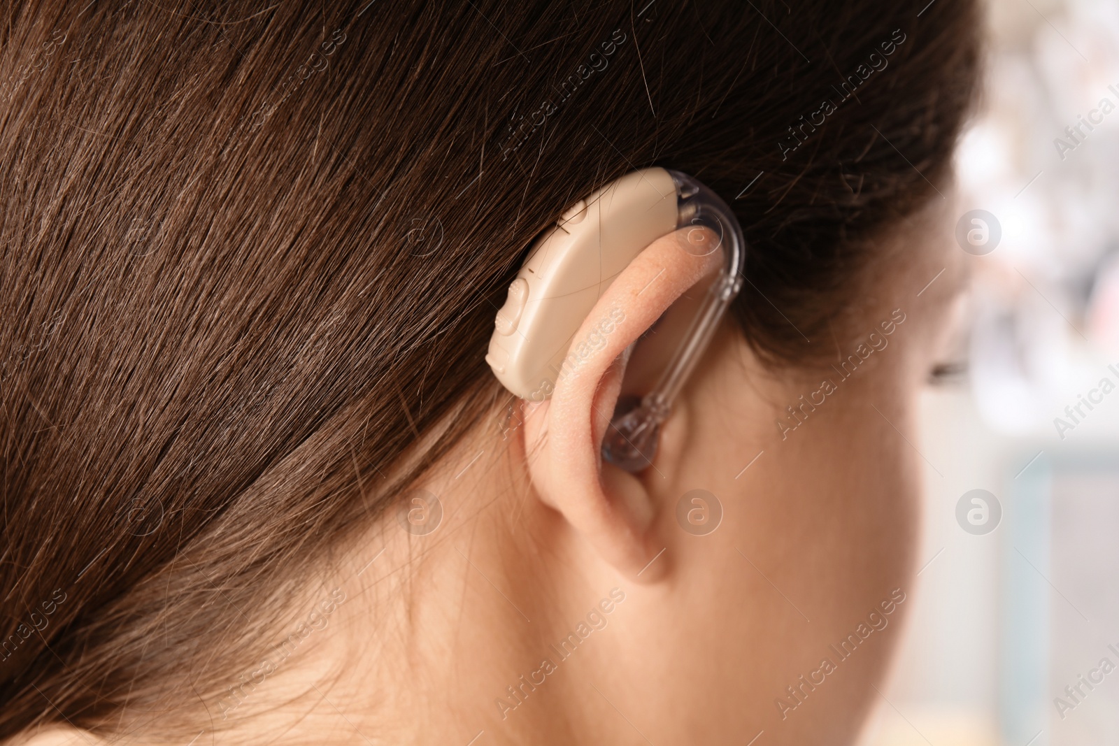 Photo of Young woman with hearing aid, closeup view
