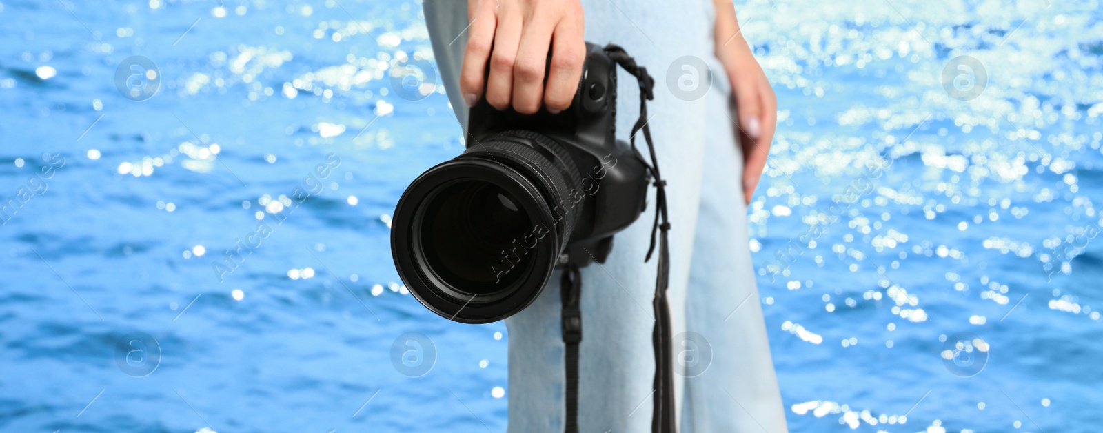 Image of Professional photographer with modern camera and blurred view of beautiful sea on sunny day. Banner design