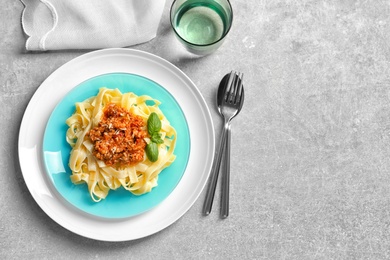 Photo of Plate with delicious pasta bolognese on light background, top view