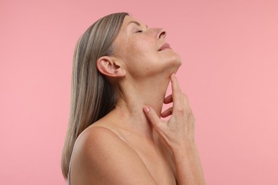 Beautiful woman with healthy skin on pink background