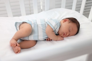 Photo of Cute newborn baby sleeping in crib. Bedtime