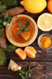 Flat lay composition with glass cup of delicious immunity boosting tea and ingredients on wooden table