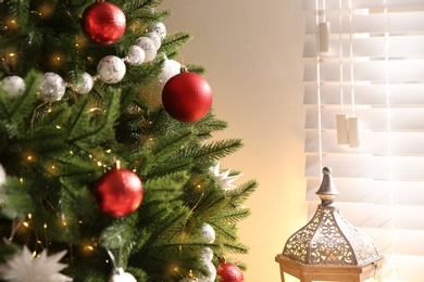 Photo of Decorated Christmas tree near window indoors, closeup. Festive interior