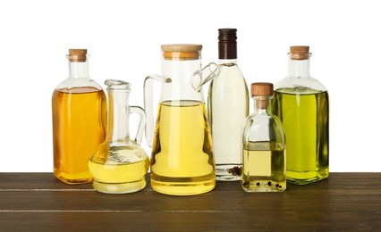Photo of Vegetable fats. Different cooking oils on wooden table against white background