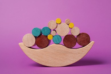 Photo of Wooden balance toy on purple background. Children's development