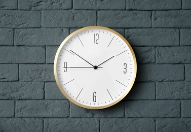 Photo of Modern clock on brick wall. Time concept