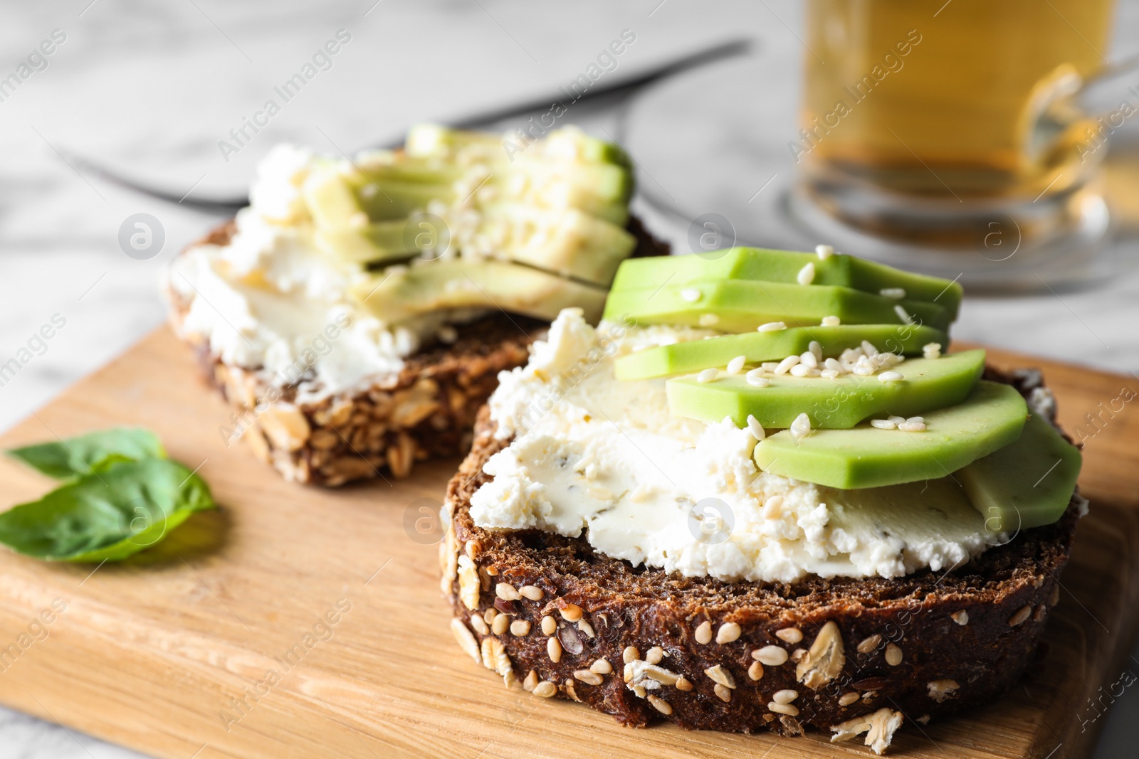 Photo of Delicious sandwich with avocado and cream cheese on table