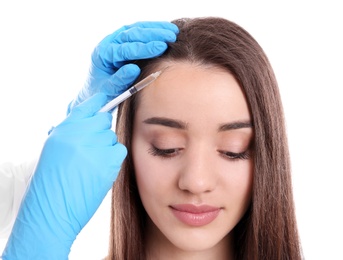 Photo of Young woman with hair loss problem receiving injection on white background