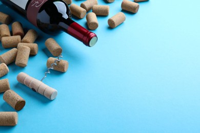 Photo of Corkscrew with wine bottle and stoppers on turquoise background. Space for text