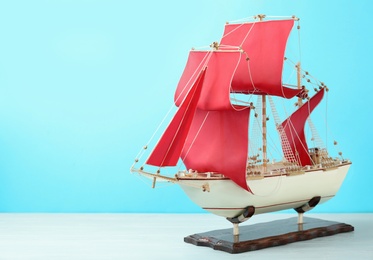 Photo of Beautiful ship model on white wooden table. Space for text