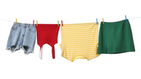 Different clothes drying on laundry line against white background