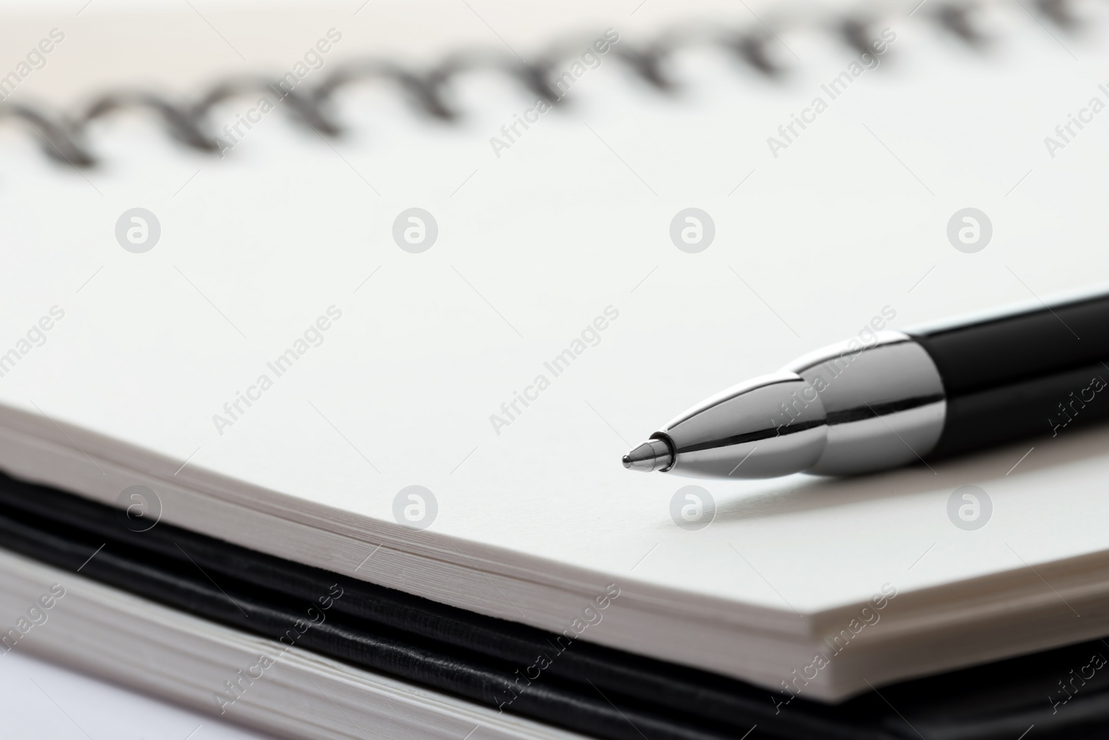 Photo of Ballpoint pen and notebooks, closeup. Space for text