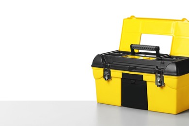 Photo of Plastic box with tools on light table against white background