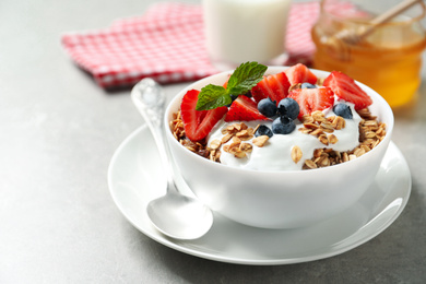 Image of Tasty granola with yogurt and berries served for breakfast on light table