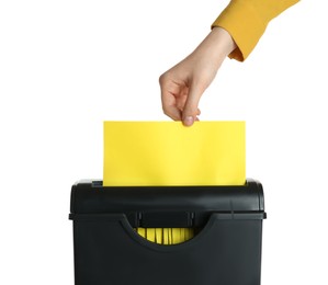 Photo of Woman destroying sheet of yellow paper with shredder on white background, closeup