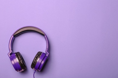 Stylish modern headphones on color background, top view. Space for text