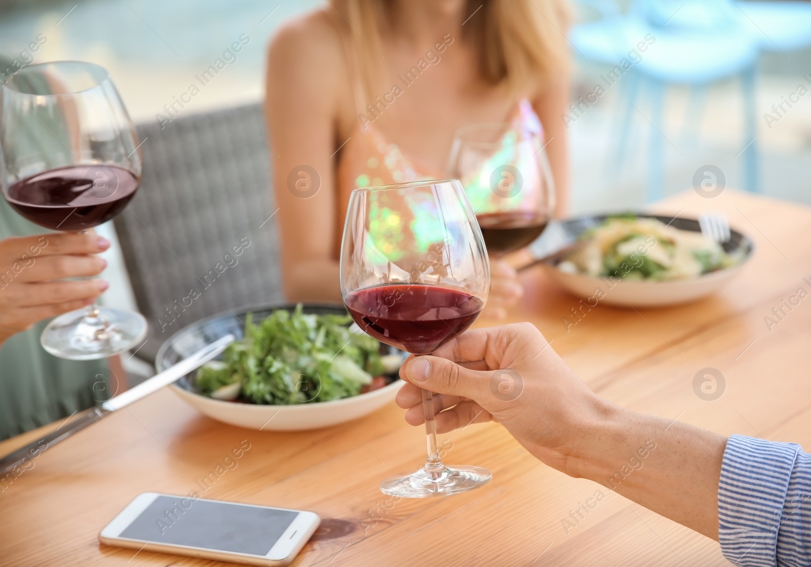 Photo of Group of friends with glasses of wine at table