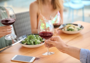 Group of friends with glasses of wine at table