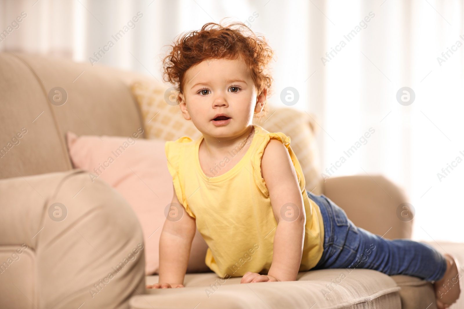 Photo of Portrait of cute little child on sofa at home