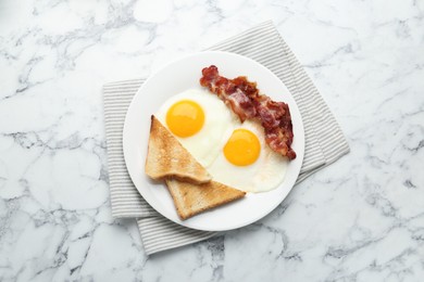 Photo of Delicious breakfast with sunny side up eggs on white marble table, top view