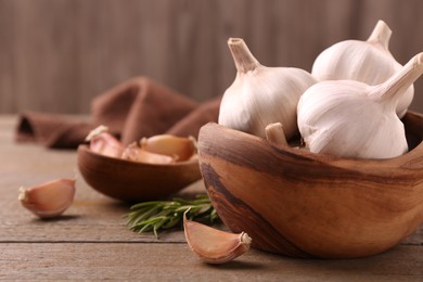 Photo of Fresh garlic on wooden table, closeup. Space for text