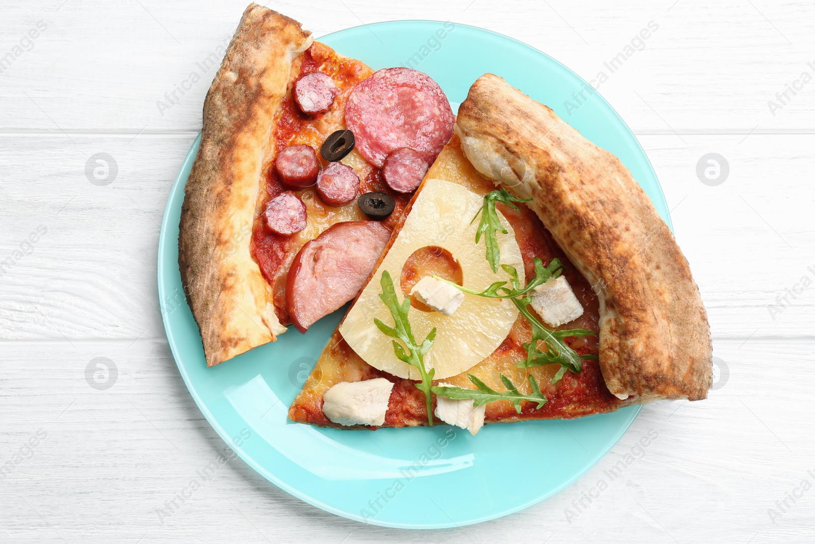 Photo of Slices of different delicious pizzas on white wooden table, top view