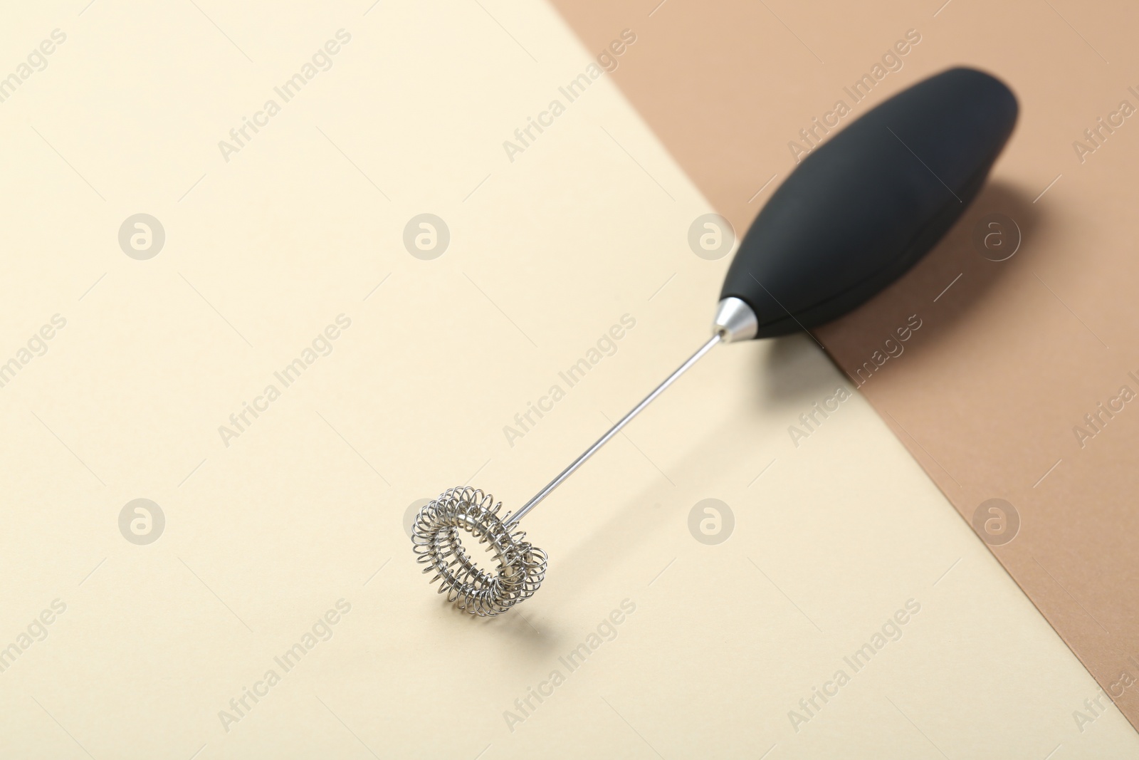 Photo of Black milk frother wand on color background, space for text