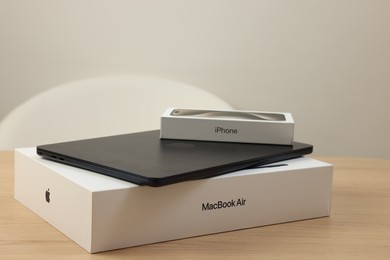 Leiden, Netherlands - October 6, 2023: Modern black MacBook Air and box from iPhone 15 Pro Max on wooden table