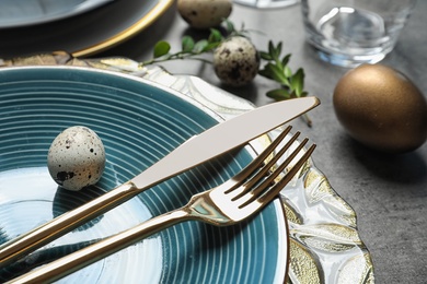 Photo of Festive Easter table setting with eggs on color background, closeup