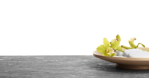 Photo of Wooden plate with orchid flowers and stones on table against white background. Space for text