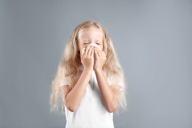 Photo of Little girl suffering from allergy on grey background