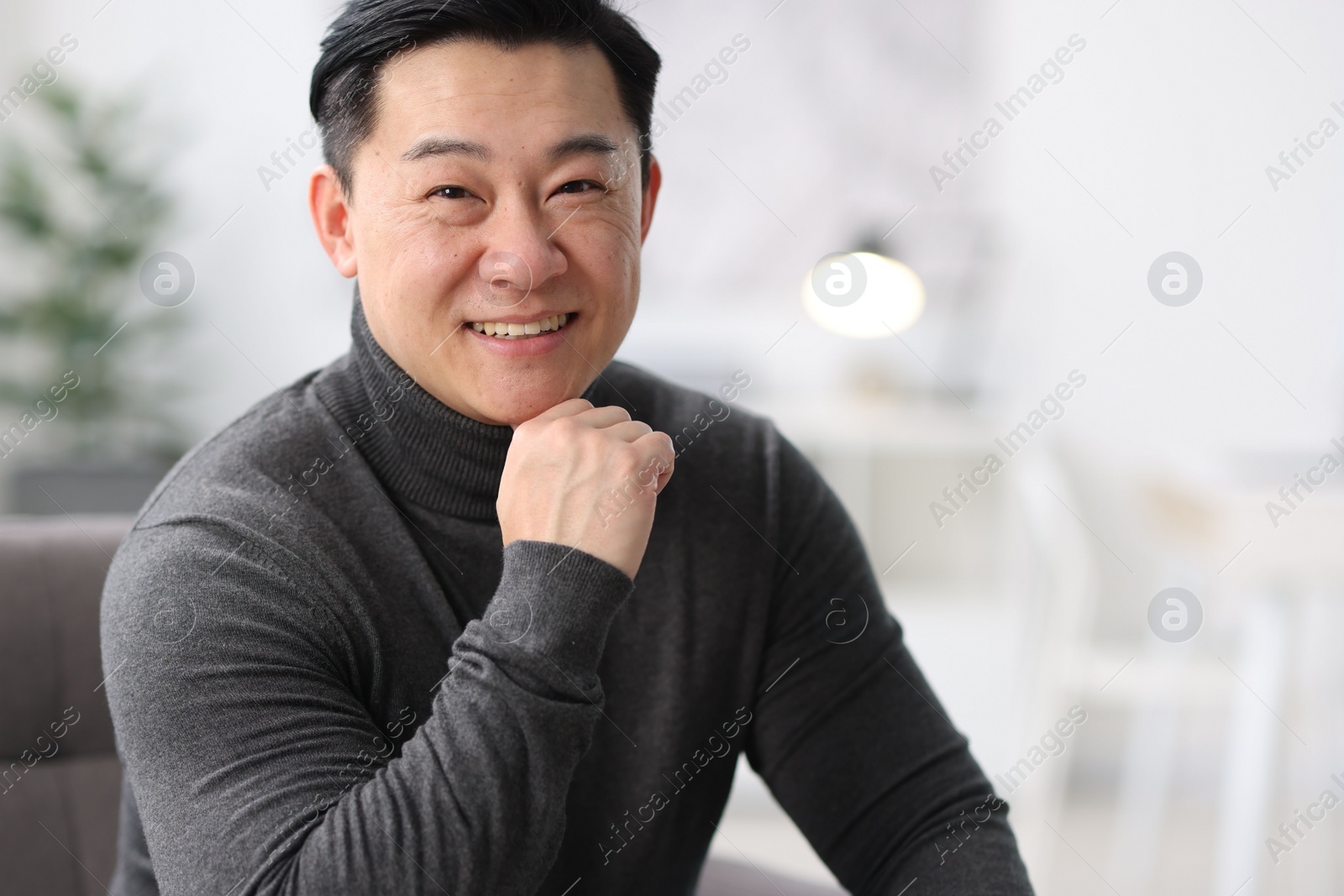 Photo of Portrait of smiling businessman on blurred background. Space for text