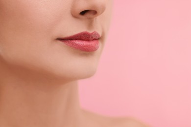 Photo of Woman with beautiful lips on pink background, closeup. Space for text