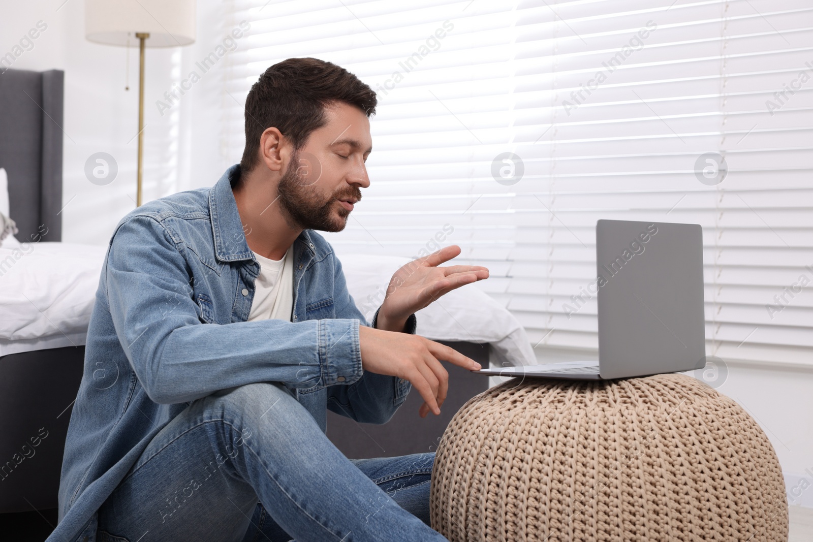 Photo of Man blowing kiss during video chat via laptop at home. Long-distance relationship