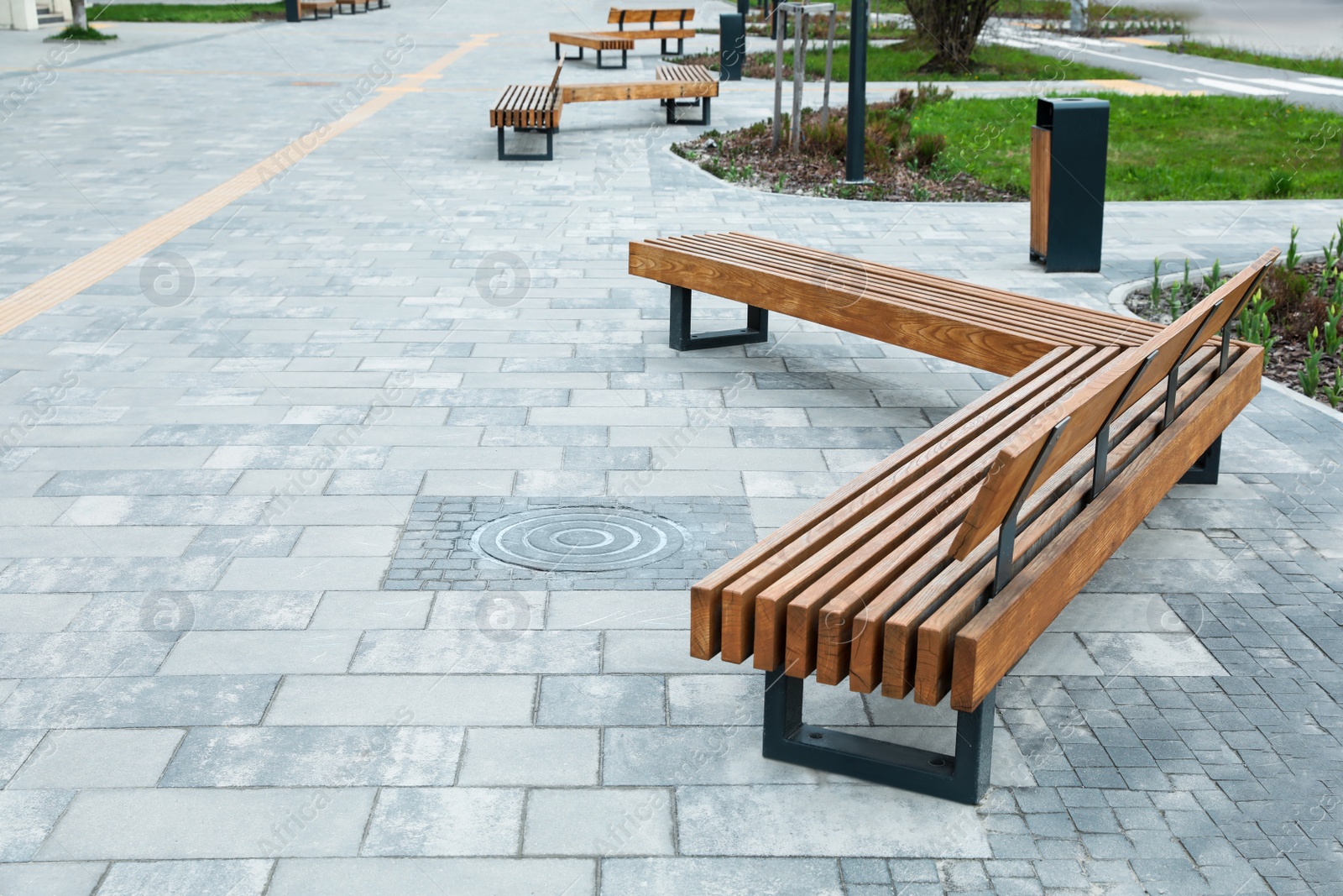 Photo of Paved city street with comfortable wooden benches