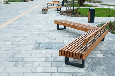 Photo of Paved city street with comfortable wooden benches