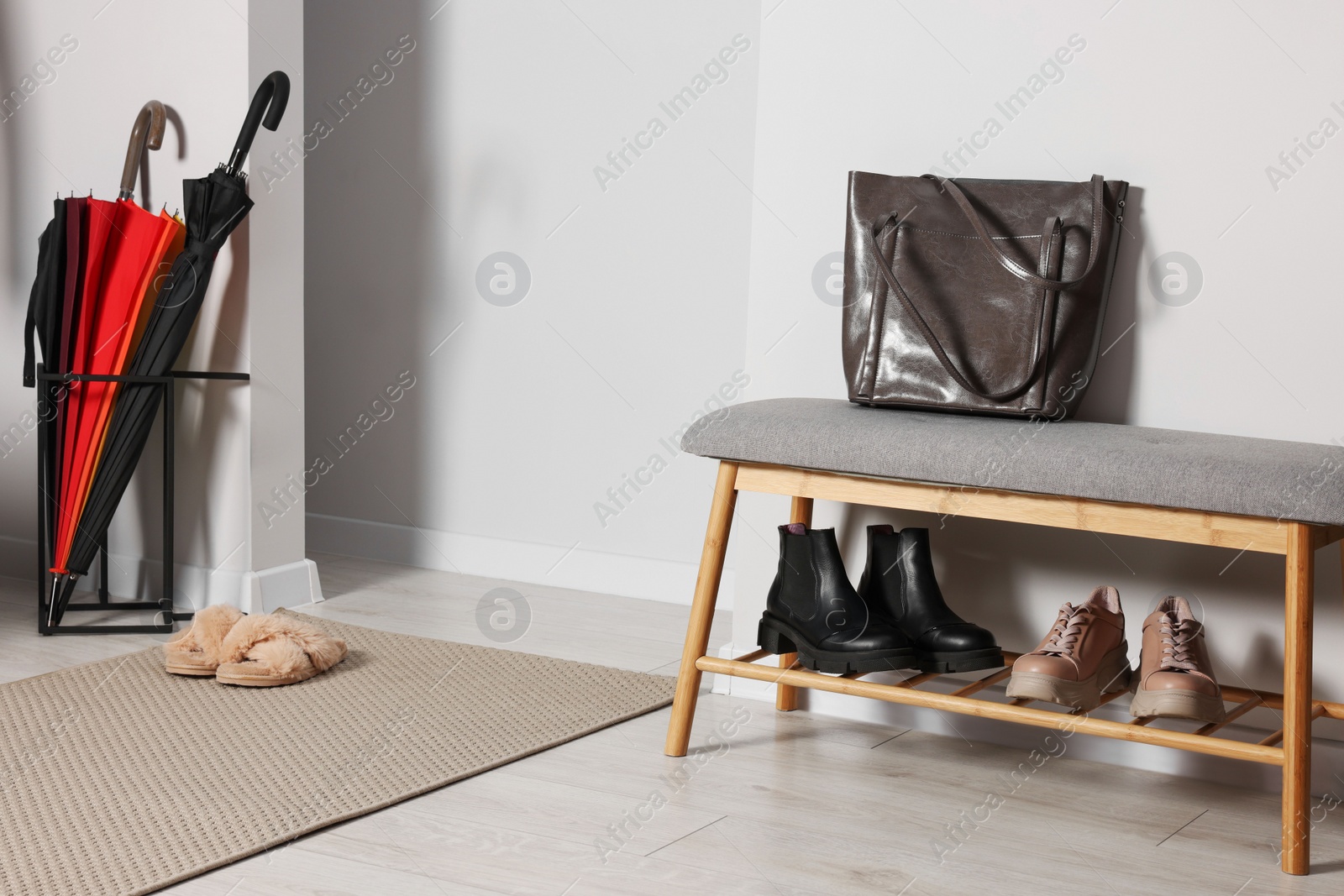 Photo of Shoe storage bench near white wall in hallway. Interior design